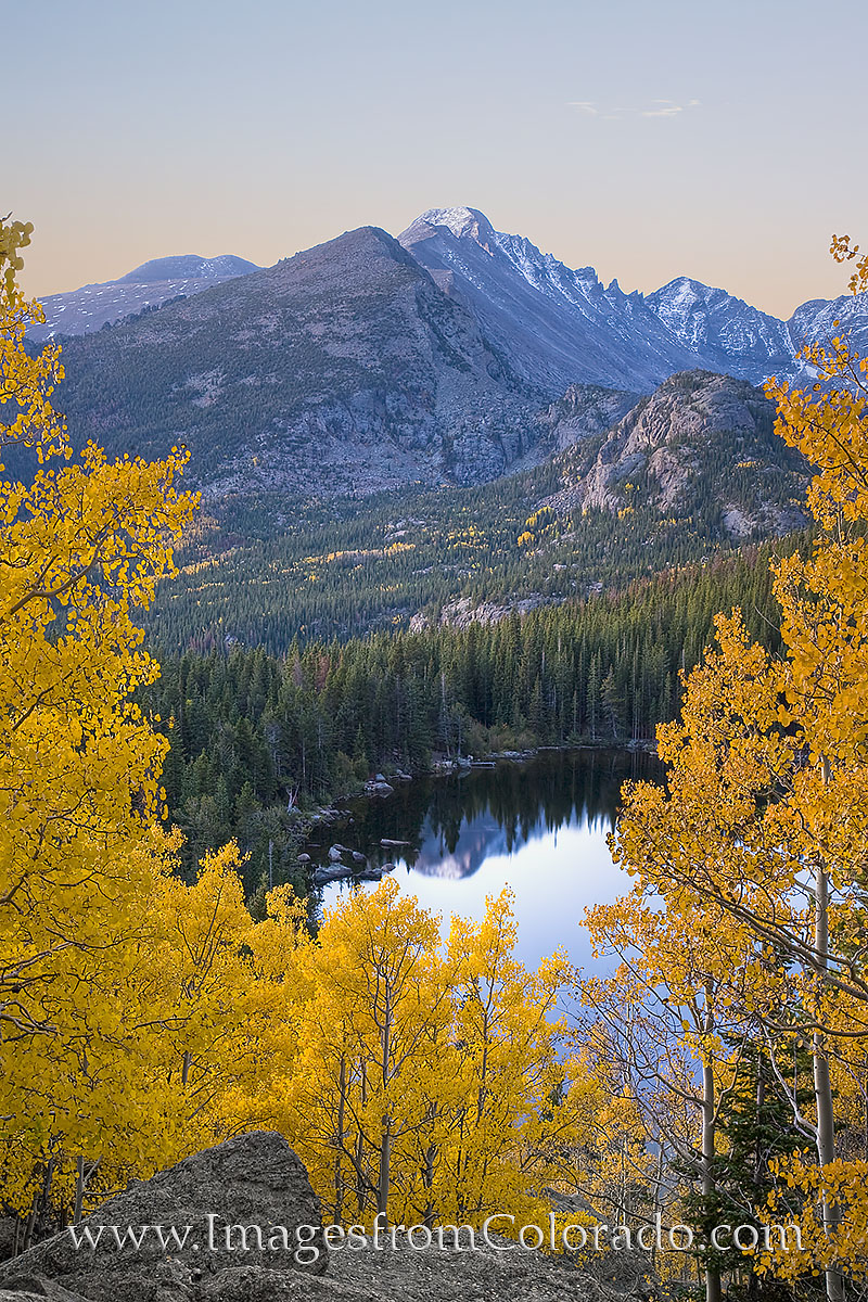 From high above Bear Lake, Longs Peak can be seen in the distance and as a reflection in the still water below. Autumn in Rocky...