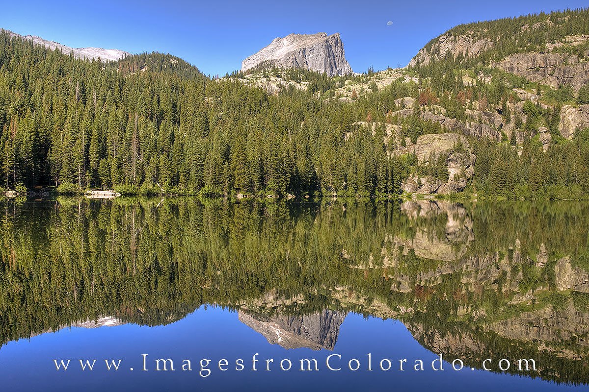 The half moon hangs above the still waters of Bear Lake in Rocky Mountain National Park. This gorgeous lake is an easy stroll...