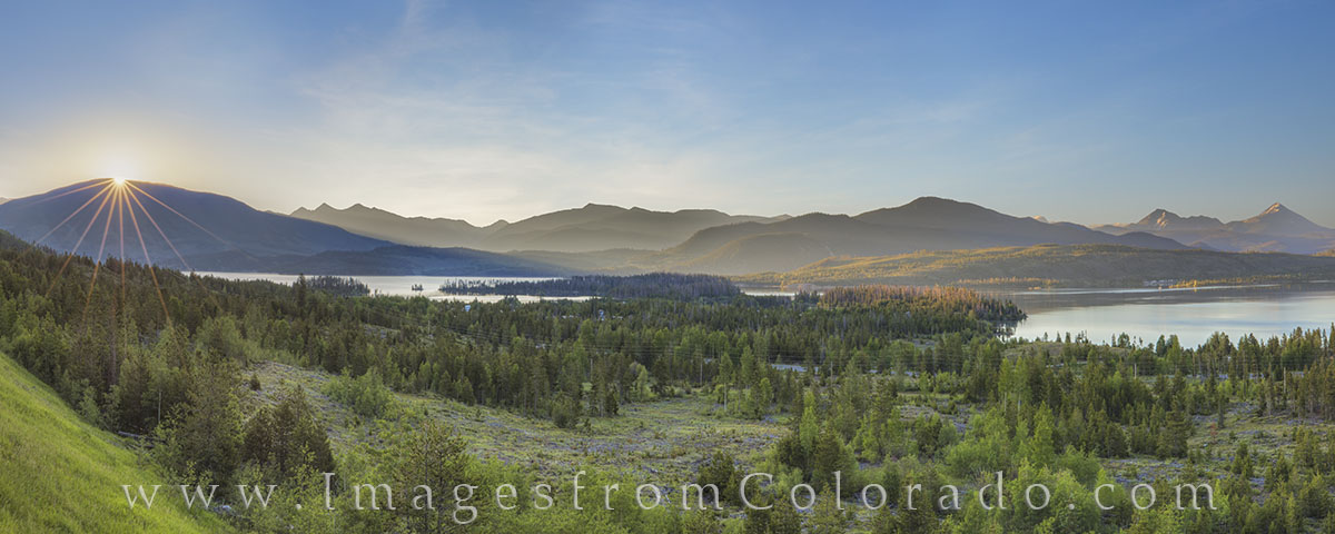 The sun peeks over a distant mountain and brings warming sunlight to the Lake Dillon Reservoir on a cold June morning. Taken...