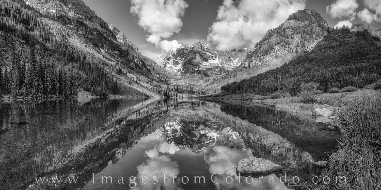 On a perfect summer morning, Maroon Peak and North Maroon Peak reflected in the calm, still water of Maroon Lake in this black...