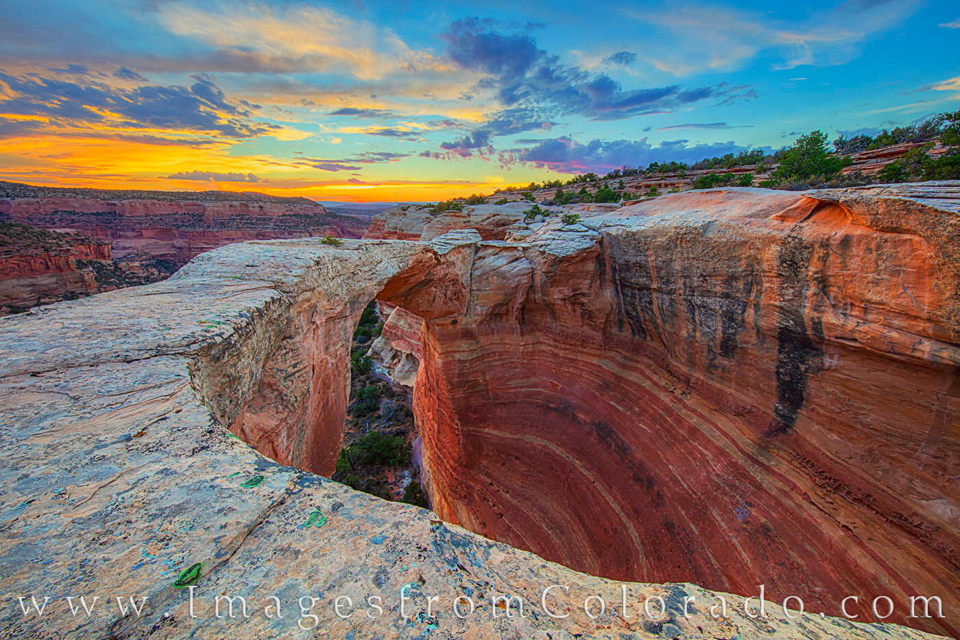 Sunset at Rattlesnake Arch is an amazing sight. From this perspective overlooking Rattlesnake Canyon, the sandstone bridge makes...