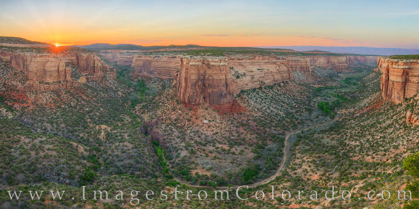 At the confluence of two canyons in Colorado National Monument, the views of the valleys below, along with a winding hiking path...