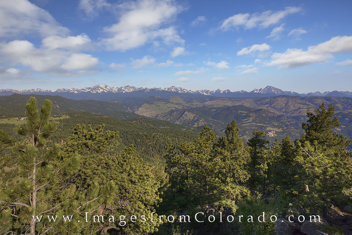 From the Flat Irons, this Colorado landscape looks across the valley towards Rocky Mountain National Park. On the right side...