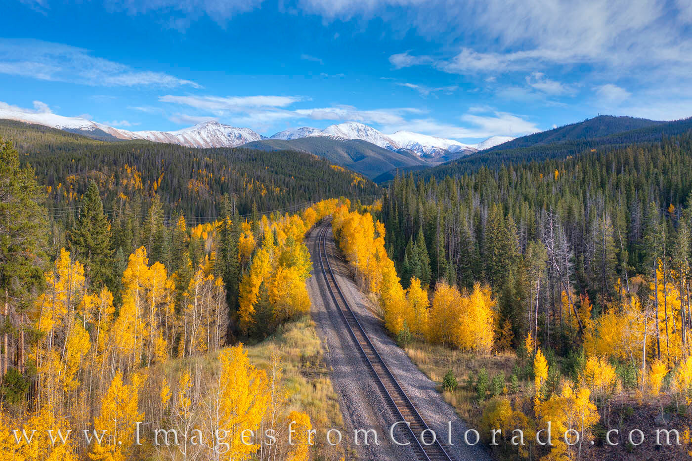Berthoud Pass as seen on a beautiful Autumn afternoon as aspen line the train tracks along Hwy 40.